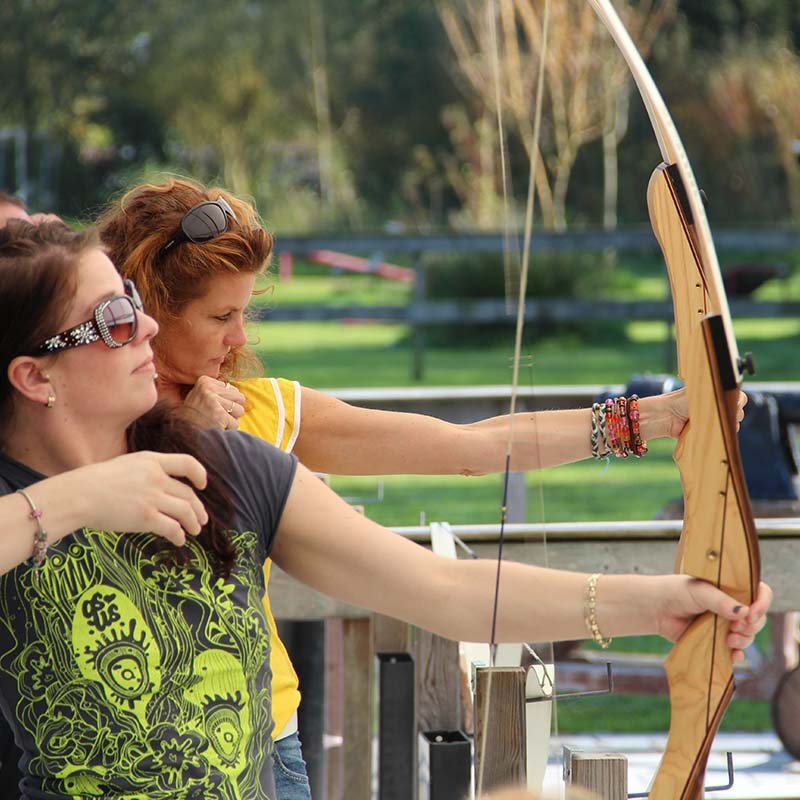 Participants aiming with a bow and arrow during archery