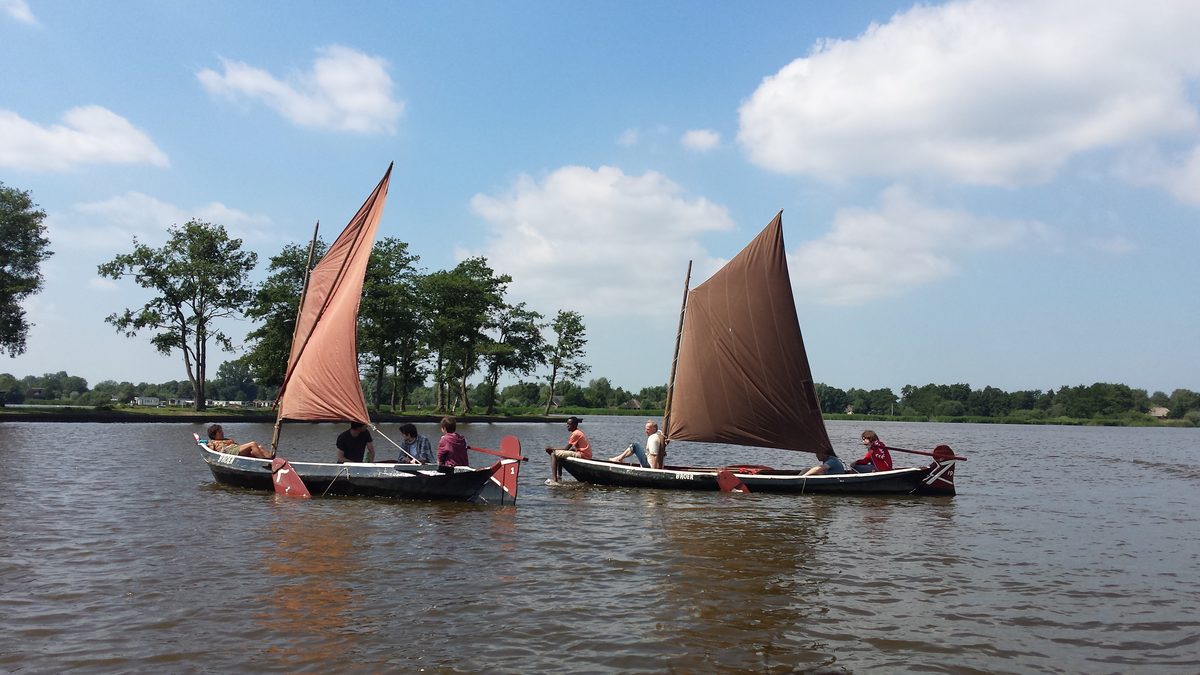 Zwei Segelpunter mit braunen Segeln auf einem See bei Giethoorn