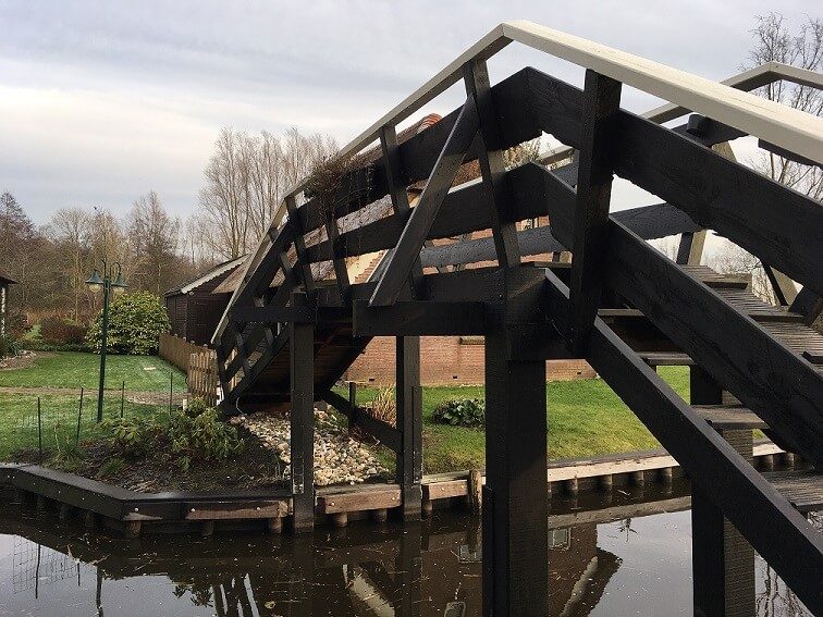 Hohe Holzbrücke über einer Gracht in Giethoorn