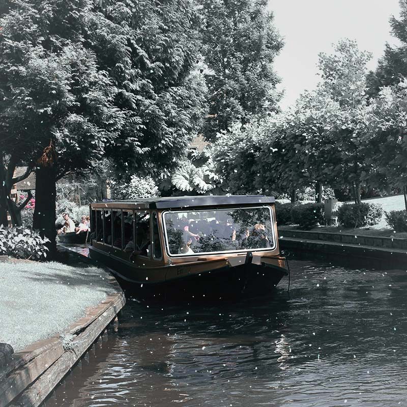 Überdachtes Rundfahrtboot in einer winterlichen Gracht in Giethoorn