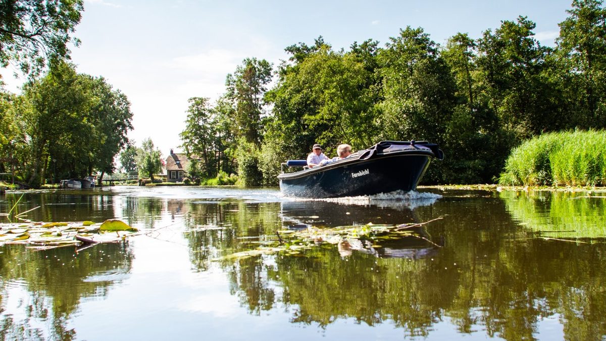 Flüsterboot fährt über das Wasser bei Giethoorn