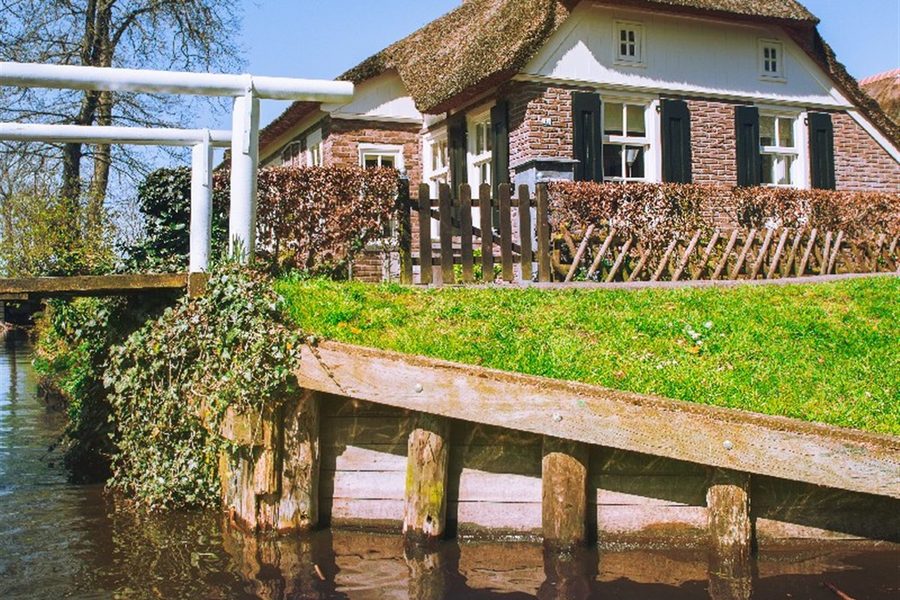 Wit bruggetje en steiger bij een boerderij in Giethoorn