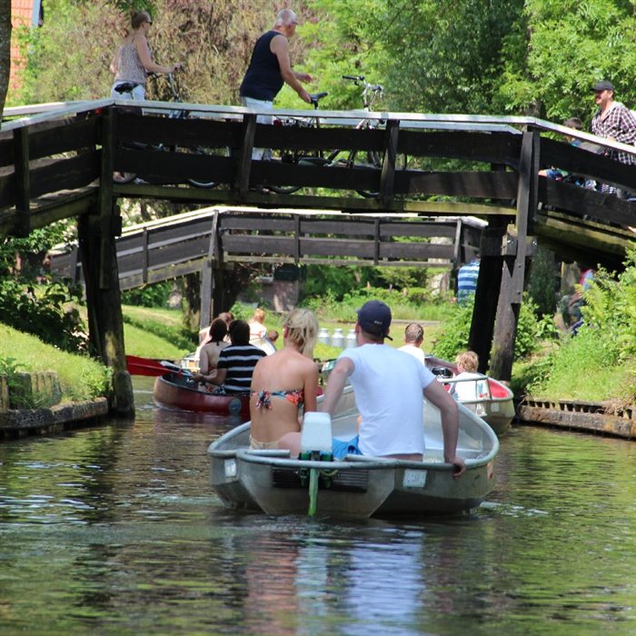 Boot mit Skipper auf dem Wasser bei Giethoorn
