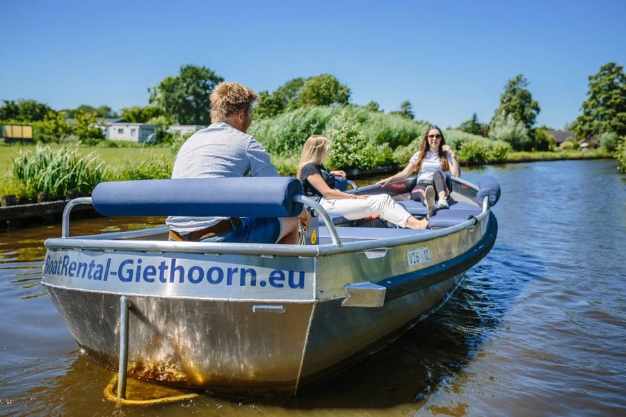 Drei Personen in einer elektrischen Mietsloep von Boatrental Giethoorn auf dem Wasser