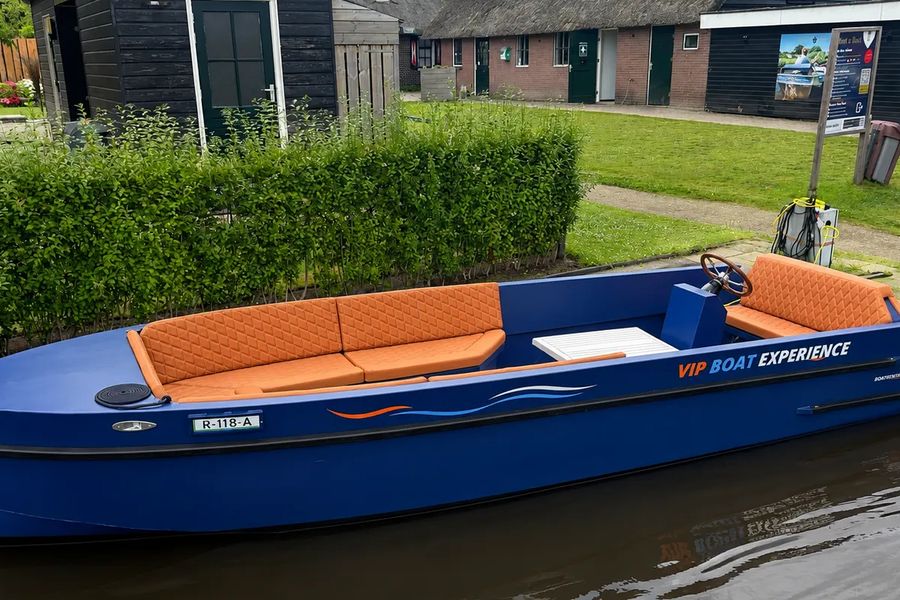 Blaue offene VIP-Sloep mit orangefarbenen Kissen am Steg von Boatrental Giethoorn