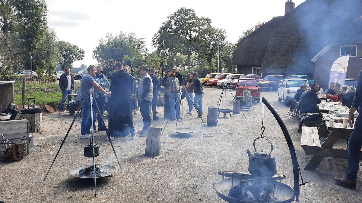 Gruppe kocht im Freien am Holzfeuer auf dem Hof von Buitenkoken Giethoorn