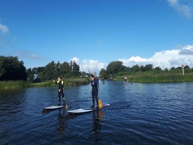 Two stand-up paddleboarders on the water at Camping D'Hof