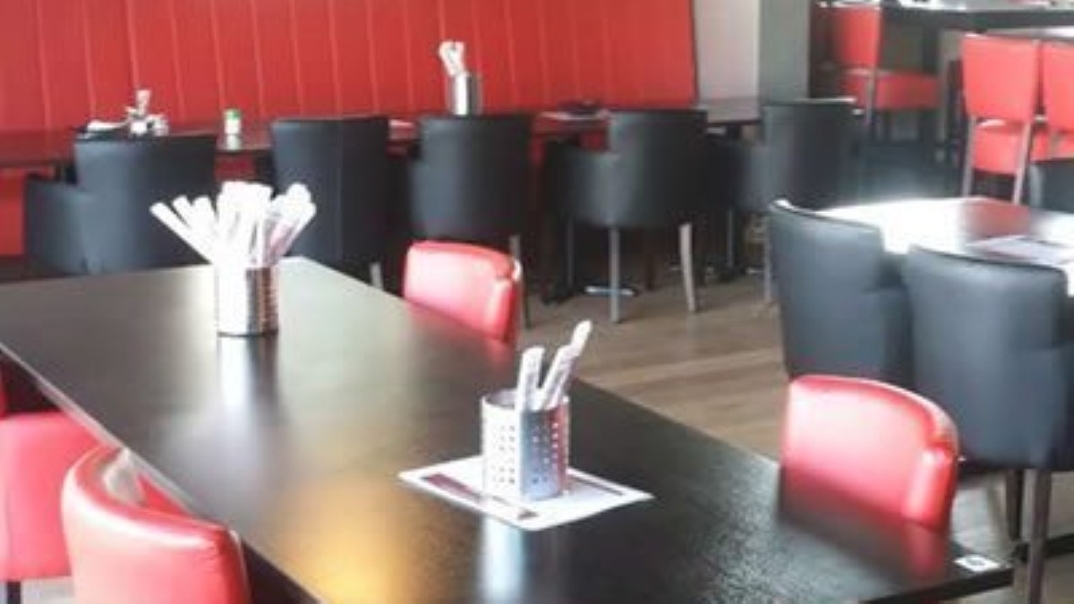 Dining room of A Niu in Giethoorn with dark tables and red and black chairs