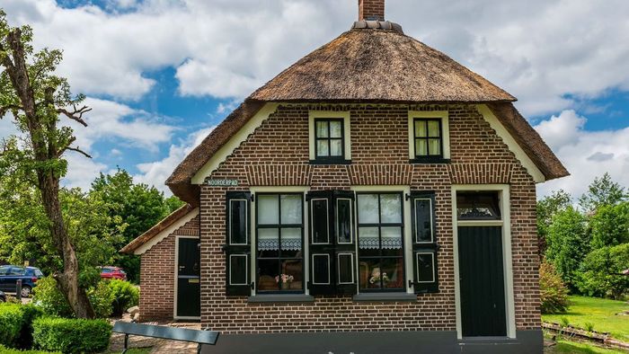 Renovated farmhouse with thatched roof and green shutters, B&B Grachtenhuis in Giethoorn