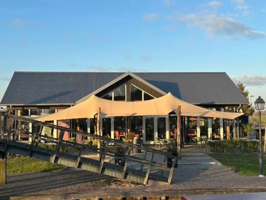 De Eetkamer van Giethoorn vom Wasser aus gesehen, mit der Terrasse unter dem Spanndach und einem Steg