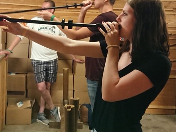 Group shooting at a target indoors with blowpipes