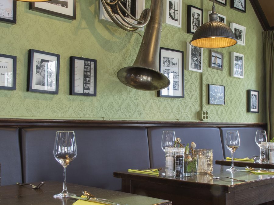 Laid tables in Grand Café Fanfare, with a tuba and black-and-white photos on the wall