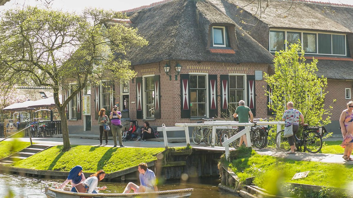 Building of Grand Café Fanfare on the village canal in Giethoorn, with a punter on the water