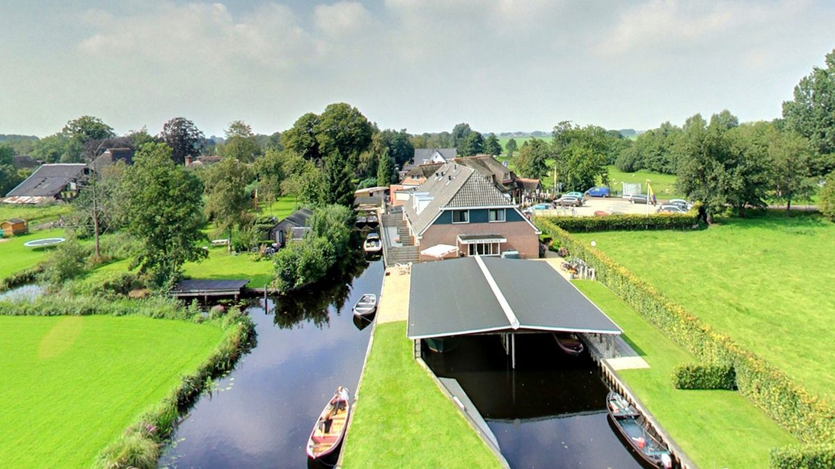 Aerial view of Hotel De Harmonie with boathouse and canal on the Beulakerweg in Giethoorn