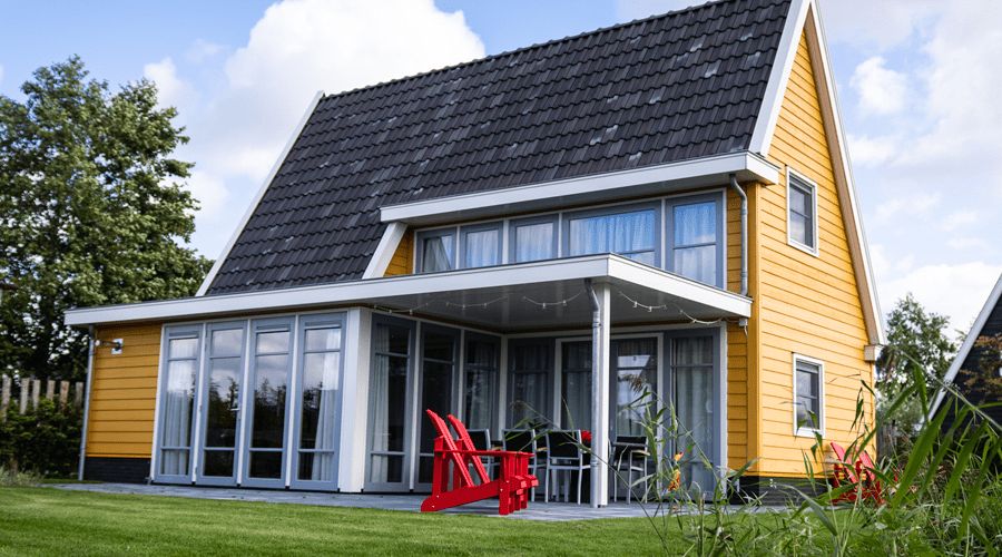 Yellow water villa with large windows and a terrace at Waterresort Bodelaeke