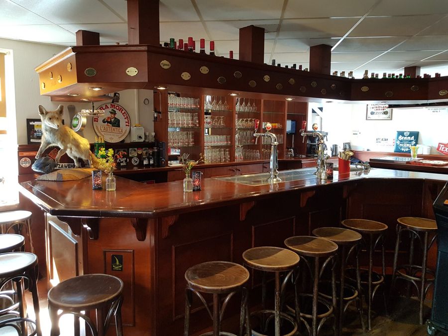 Wooden bar with bar stools in the café of De Otterskooi