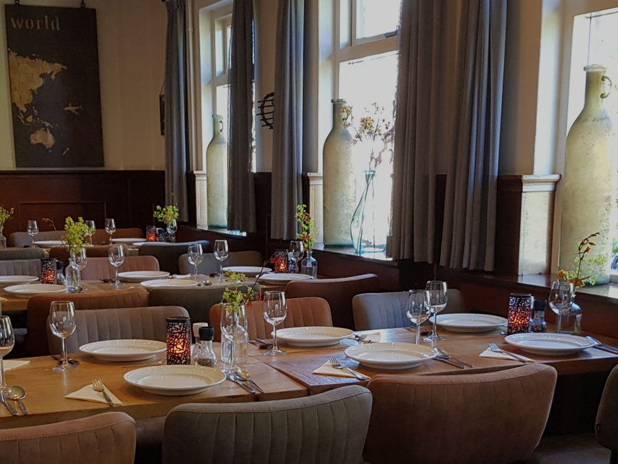 Laid tables in a dining room of De Otterskooi in Dwarsgracht