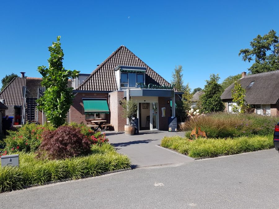 Building of De Otterskooi in Dwarsgracht with a flowering garden in front