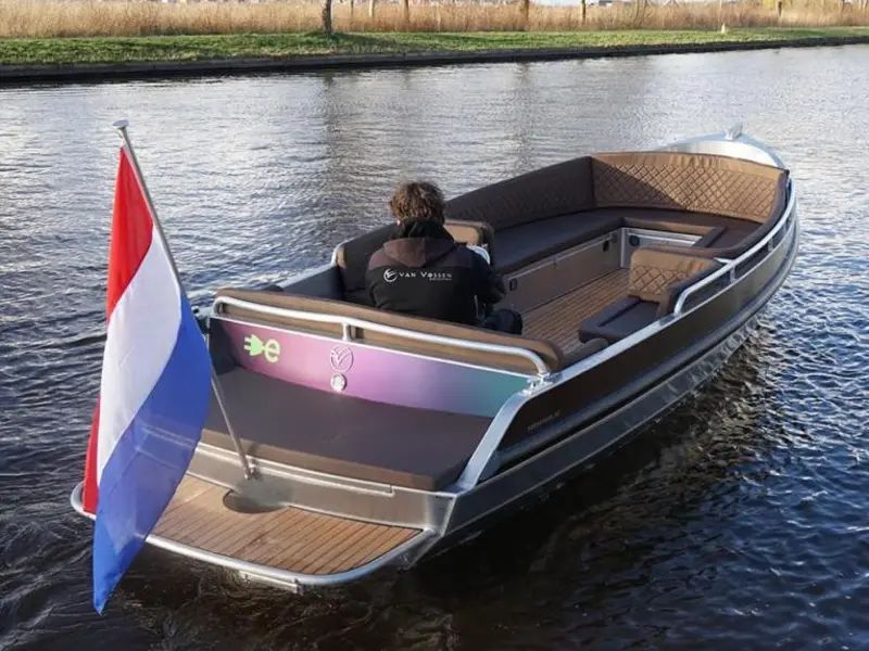 Dwarsgracht Deluxe sloop with a steering wheel and cushions on the water