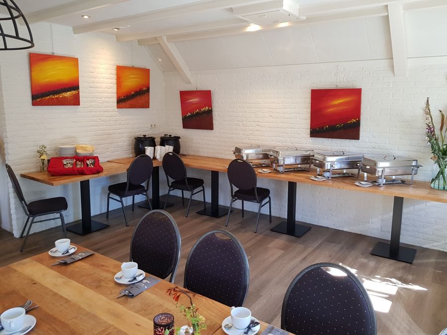 Room at De Otterskooi with tables, chairs and a buffet set-up along the wall