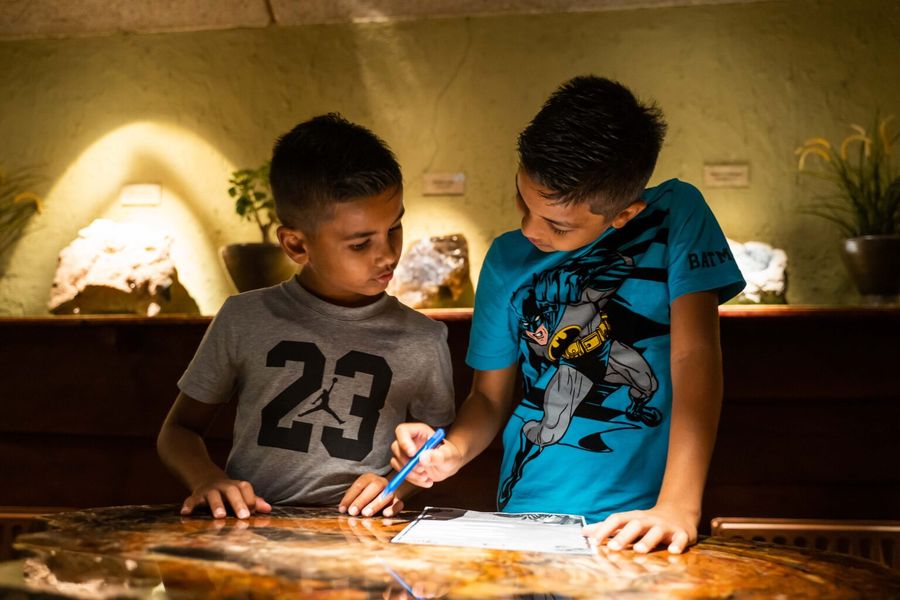 Zwei Jungen füllen im Museum von De Oude Aarde den Fragebogen der Schnitzeljagd aus