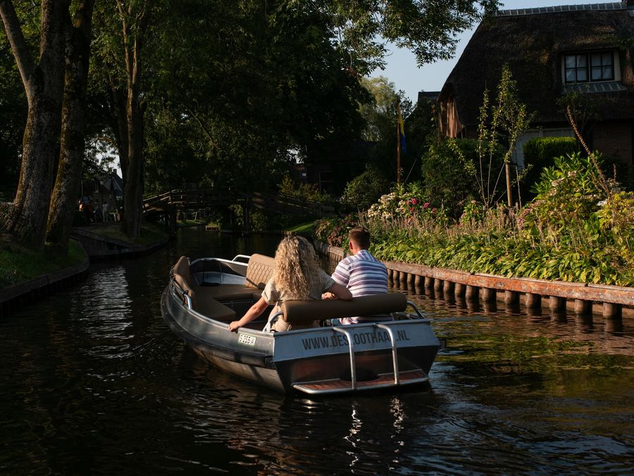 Zwei Gäste in einer Loungesloep von De Sloothaak auf einer Gracht in der Abendsonne
