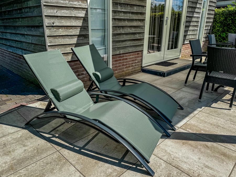 Loungesessel auf der überdachten Terrasse eines Ferienhauses von De Sloothaak