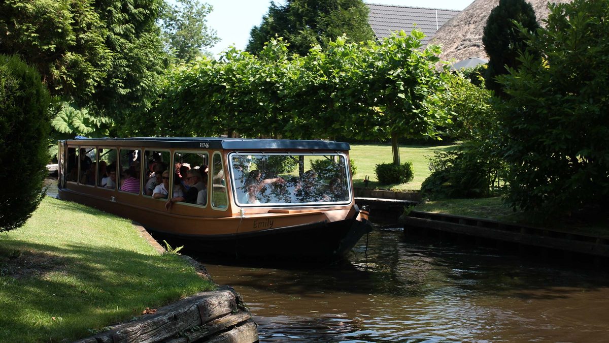Überdachtes Rundfahrtboot von Hollands Venetië auf einer Gracht in Giethoorn