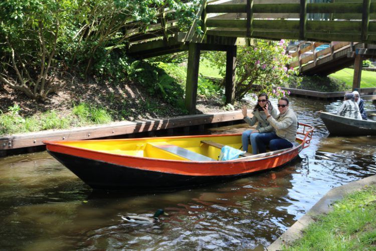Zwei Personen in einem Flüsterboot von Koppers Giethoorn unter einer Holzbrücke