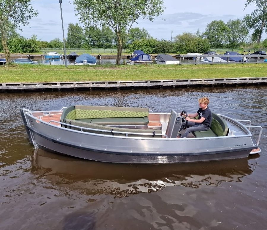 Graue Sloep Deluxe von Koppers Giethoorn mit einem Skipper am Steuer auf offenem Wasser