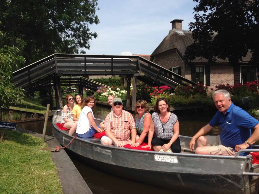 Gruppe in einem Flüsterboot von Mol Groenewegen an einer kleinen Holzbrücke über die Gracht in Giethoorn