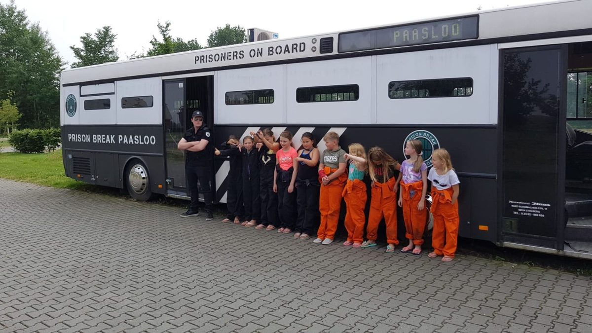 Group in prison overalls in front of the prison bus of Prison Break Paasloo