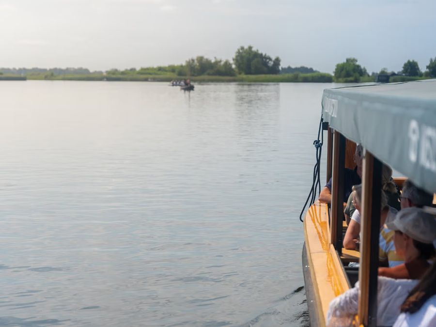 De Rietstulp tour boat with passengers on the open water of a lake near Giethoorn