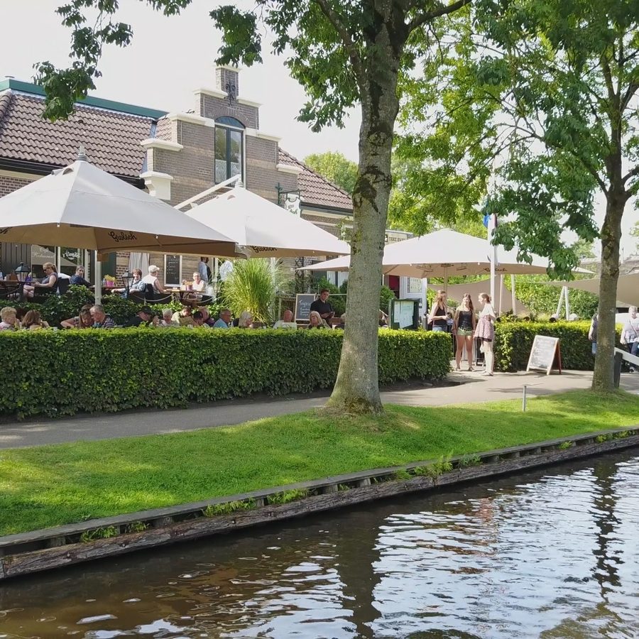 Terrasse von 't Vonder mit Sonnenschirmen an der Dorfgracht von Giethoorn
