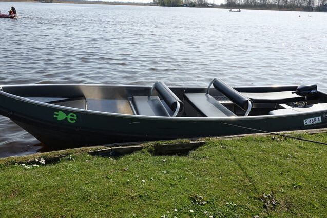 Elektroboot Boot Kragge Deluxe von Restaurant 141 am grasbewachsenen Ufer eines Sees