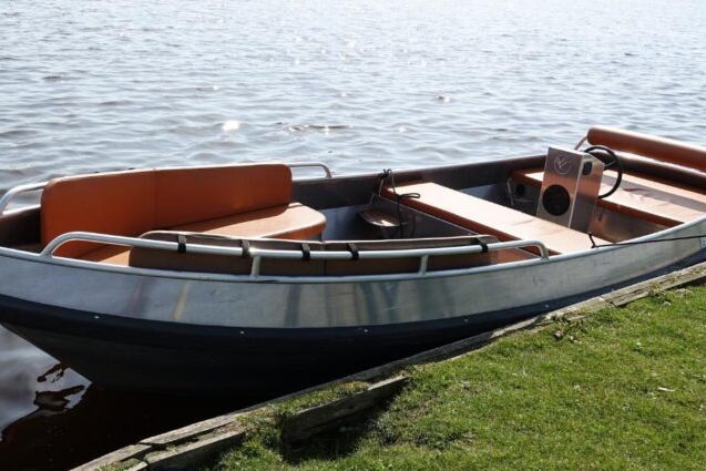 Sloep Giethoorn Deluxe von Restaurant 141 mit Kissen und einem Tischchen am Ufer