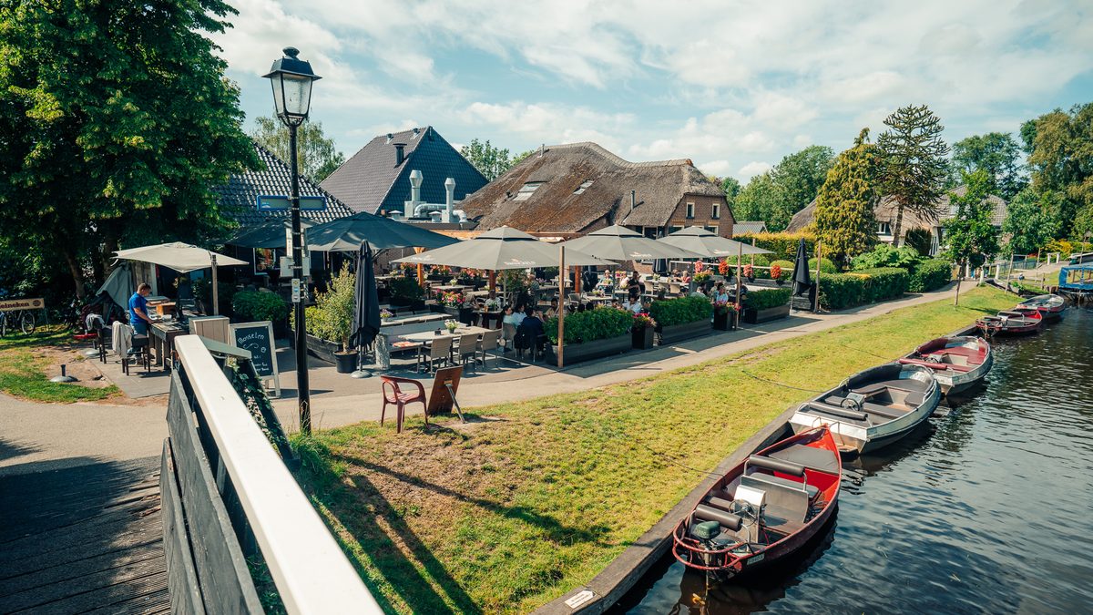 Terrasse von Smit Giethoorn an der Dorfgracht mit Mietbooten am Kai
