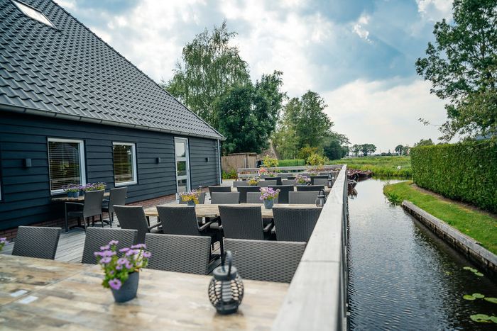 Private Terrasse von Smit Giethoorn mit Tischen neben dem Saal, an einer Fahrrinne