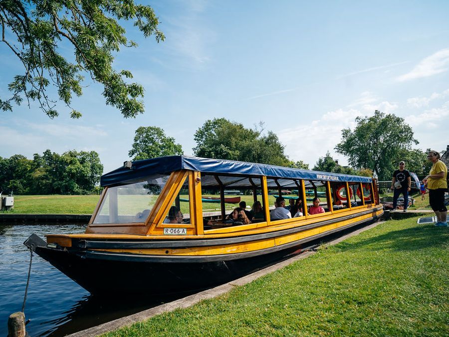 Überdachtes Rundfahrtboot von Smit Giethoorn am Ufer der Fahrrinne