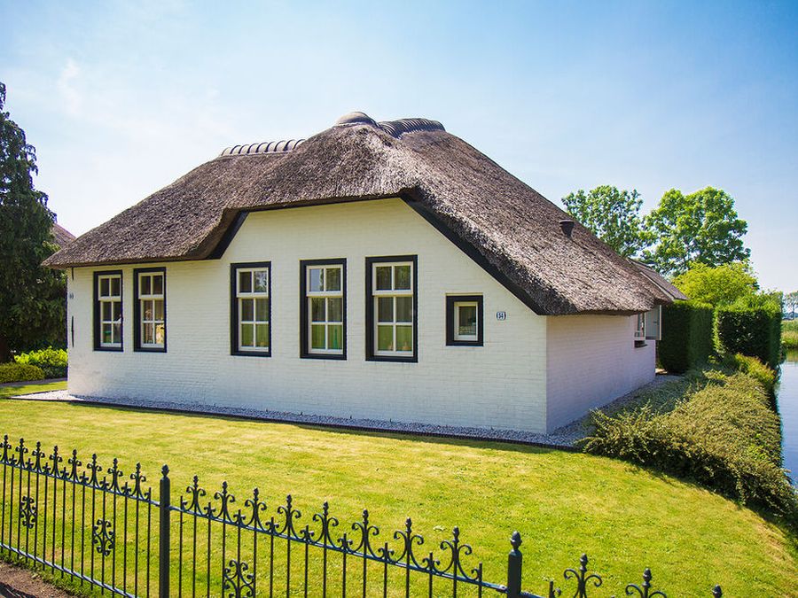 Weißer Ferienbauernhof mit Reetdach am Wasser in Giethoorn