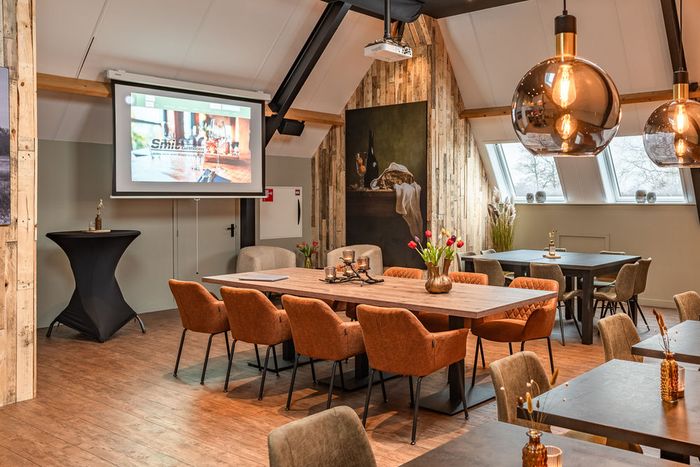 Dachboden von Smit Giethoorn mit langem Tisch, Holzbalken und einer Projektionsfläche