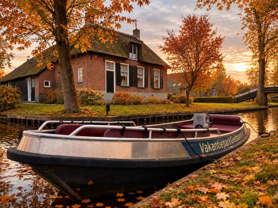 Sloep von Vakantiepark Giethoorn am Ufer zwischen Herbstblättern