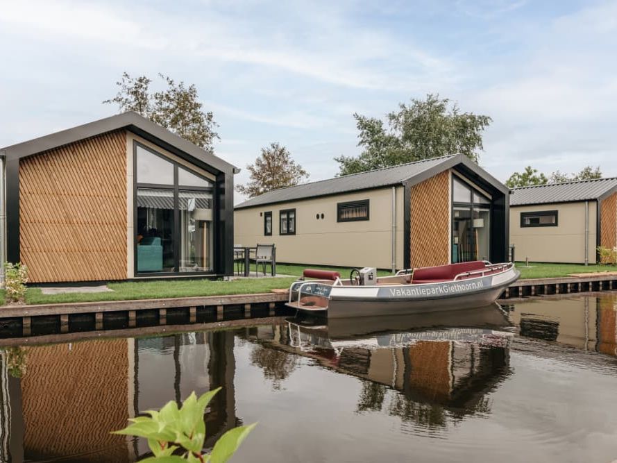 Moderne Lodges von Vakantiepark Giethoorn mit Sloepen an den Stegen