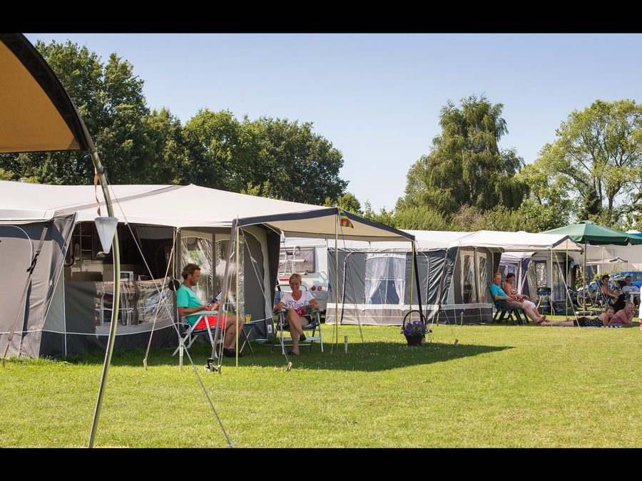Campers with awnings on the grass field of Vakantiepark 't Akkertien