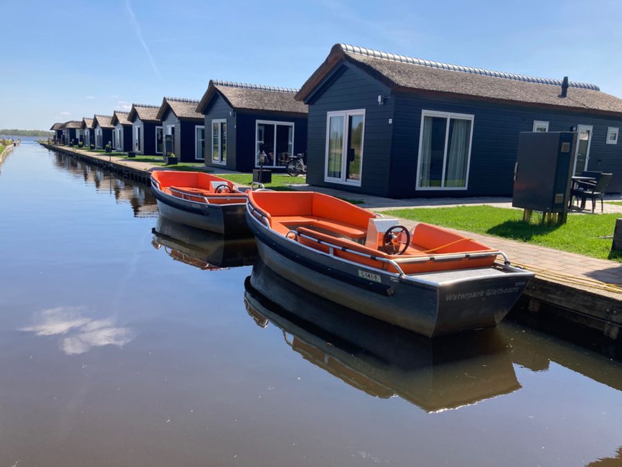 Two rental boats from Waterpark Giethoorn at the quay in front of the chalets