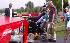 Ein Elektrorollstuhl wird mit dem Lift an Bord eines Rundfahrtbootes gebracht