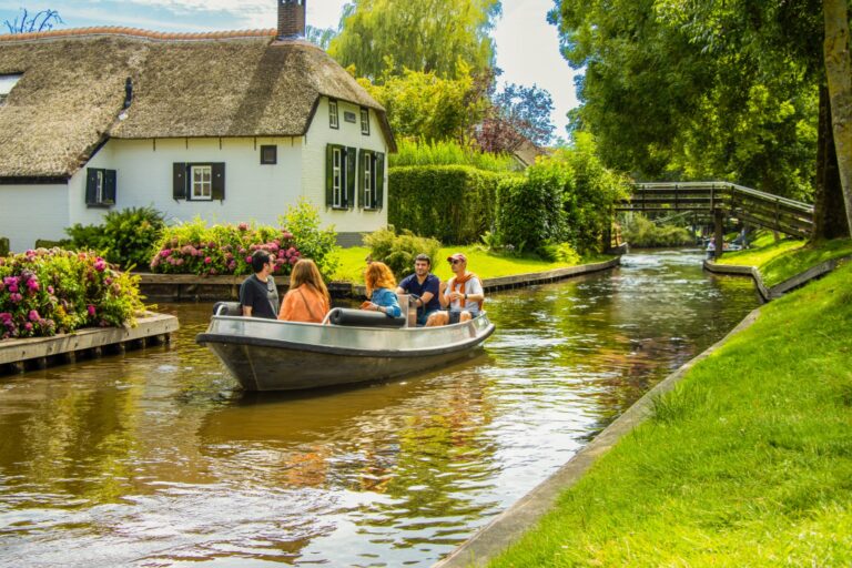 Canal in Giethoorn with thatched roofs and a boat