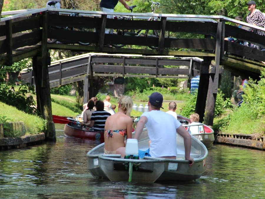Boats sailing under wooden bridges in Giethoorn